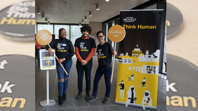 Three Think Human student ambassadors wait to guide visitors. 